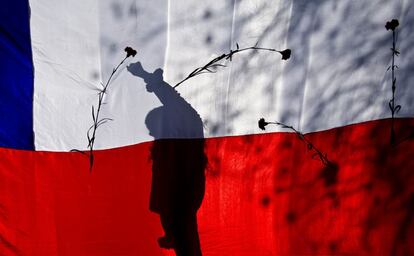 Un activista de la organización Derechos Humanos en Chile proyecta su sombra sobre la bandera nacional chilena durante una manifestación en Santiago (Chile), el 7 de septiembre de 2014.