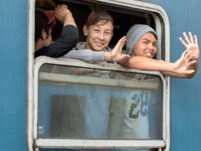 Un grupo de refugiados saluda desde un tren que parte desde Budapest (Hungr&iacute;a), con destino Austria.