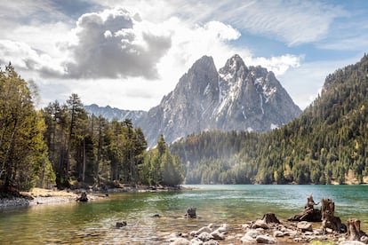 LLEIDA. ESTANY DE SANT MAURICI. Circos de paredes escarpadas, valles en forma de U, un gigantesco esturreo de piedras de todo tipo como producto de las morrenas y dos centenares de lagos convierten al parque nacional de Aigüestortes y Estany de Sant Maurici en un ecosistema único. Fue creado en 1955 y alberga dentro de sus 14.119 hectáreas dos zonas diferenciadas, que condicionan la morfología y el acceso. Aigüestortes (aguas retorcidas) es la parte más occidental y se enhebra en torno al río Sant Nicolau. Por el lado oriental, subiendo desde Espot, la morfología es diferente, pero no menos espectacular. Aquí las grandes cresterías de granito, afiladas como la hoja de una daga, sirven de envoltorio a decenas de lagos. El más famoso, el Estany de Sant Maurici, contribuye con la segunda parte del nombre de este entorno natural. 
