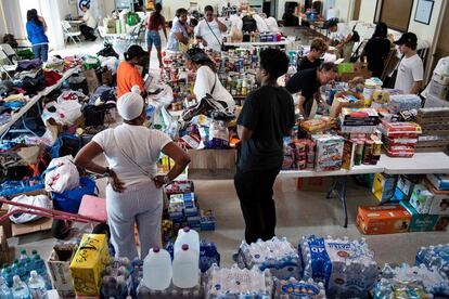 Un grupo de personas reúne donaciones realizadas para los afectados por el huracán Dorian en un iglesia de Miami, Florida.