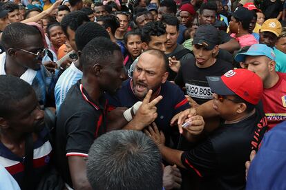 People argue while waiting in line to process their paperwork, on May 8.