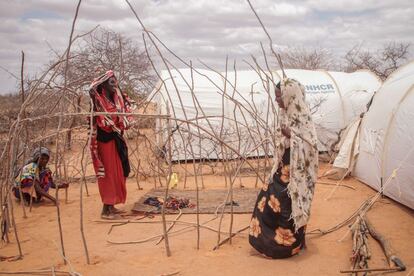 Dos mujeres sonríen mientras tratan de instalar una extensión a su refugio, el 70% de la población de Dadaab son mujeres y niños principalmente.