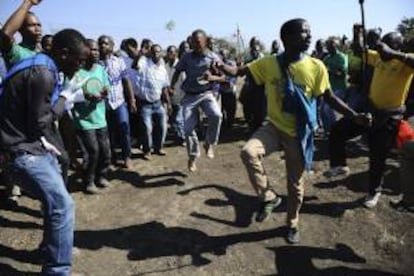 Varios trabajadores de la mina de platino de Lonmin en Marikana bailan y protestan mientras permanecen en una nueva huelga ilegal convocada hoy, en la ciudad surafricana de Rustemburg, Sudáfrica, hoy, martes 14 de mayo de 2013.