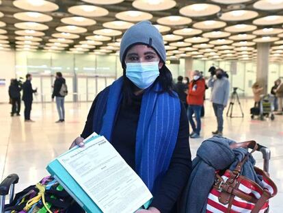 Una joven muestra el resultado de su PCR a su llegada al aeropuerto Adolfo Suárez-Barajas en Madrid, este lunes, donde comienza la exigencia de pruebas PCR para pasajeros de vuelos procedentes de países de riesgo. 