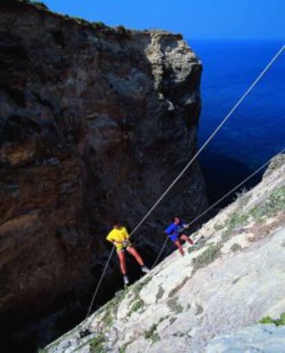 Turistas practicando escalada en las colinas de la isla de Malta.