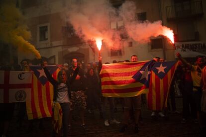 Manifestantes sostienen banderas catalanas independentistas y bengalas durante una protesta en Barcelona.