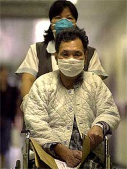 Un paciente y una enfermera, con máscarillas, en un hospital de Hong Kong.