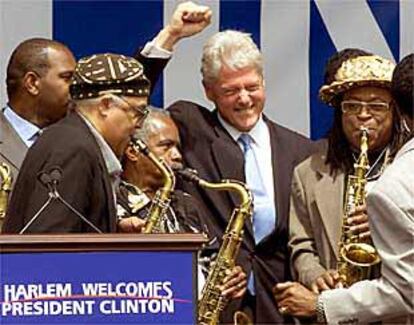 Un grupo de músicos da la bienvenida a Clinton en la inauguración de la oficina del ex presidente en Harlem.