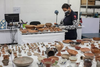 Una investigadora del INAH inspecciona las piezas repatriadas.