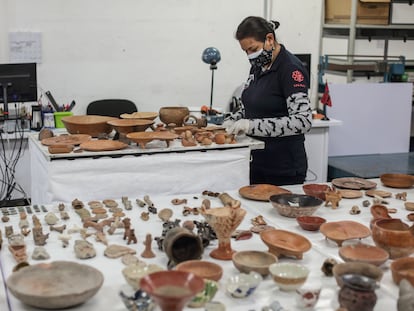 Una investigadora del INAH inspecciona las piezas repatriadas.