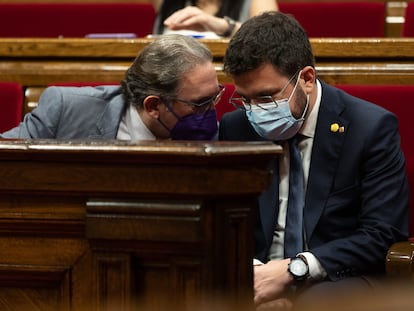 El presidente catalán, Pere Aragonès (der), conversa con el 'conseller' de Economia Jaume Giro (I), durante el pleno de la semana pasada en el Parlament.