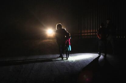 Una madre hondureña camina con sus hijos al lado de la valla fronteriza, la madre decidió entregarse a los agentes de la Patrulla Fronteriza ante los peligros y el cansancio que le asediaban. 
