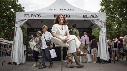 Elvira Lindo, sentada frente al estand de EL PAÍS en la Feria del Libro.