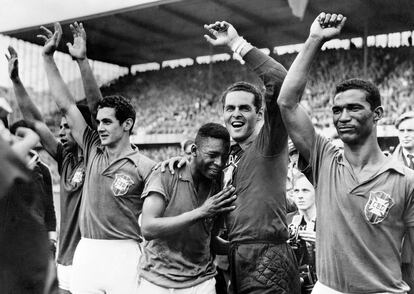 20 de junio de 1958. Pelé (centro), con 17 años, llora de alegría en el hombro del portero Gylmar dos Santos Naves tras la victoria de Brasil ante la anfitriona Suecia por 5-2 en el estadio Rasunda de Solna ante 49.737 espectadores. Brasil vestía de azul, Suecia, de amarillo.