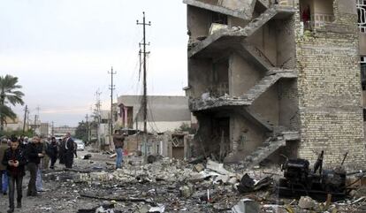 Un grupo de personas permanece en el lugar donde ayer explosion&oacute; un coche bomba, en Bagdad, Irak, el pasado 12 de enero.