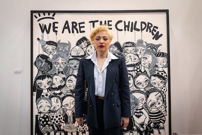 La artista Mon Laferte posa junto a su obra “We are the Children”, en Aninat Galería, de ZONA MACO. 