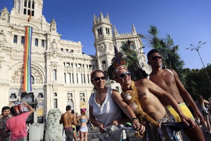 Participantes en la celebración del Orgullo Gay posan el pasado julio ante la sede del Ayuntamiento de Madrid, en Cibeles. Colgando del edificio, una bandera del movimiento de más de 20 metros de longitud.