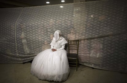 Rivka Hannah Krois, novia judía ultra-ortodoxa observa a su novio durante el baile nupcial tras la ceremonia de boda tradicional en el barrio Mea Shearim de Jerusalén.