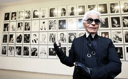 Karl Lagerfeld posa delante de una serie de retratos que se expone en París.