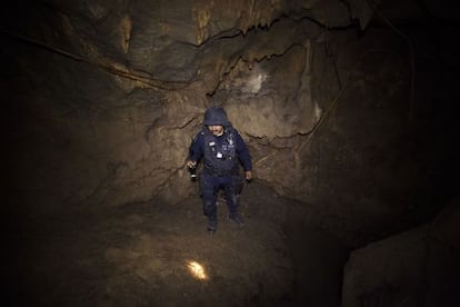 A policeman searches the cave where La Tuta hid out.