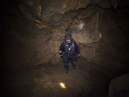 A policeman searches the cave where La Tuta hid out.