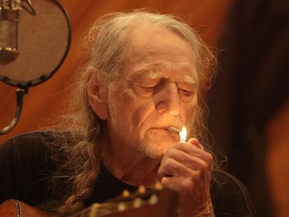 El músico Willie Nelson enciende un cigarrillo de marihuana dentro de un estudio de grabación.
