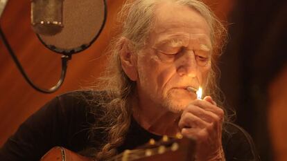 El músico Willie Nelson enciende un cigarrillo de marihuana dentro de un estudio de grabación.