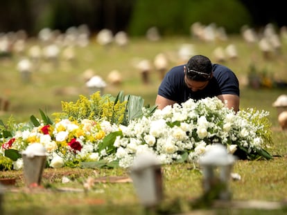 Homem visita uma tumba no cemitério Campo da Esperança, em Brasília, no dia 23 de março.