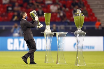 Un operario coloca el trofeo en el campo antes de disputarse el partido.