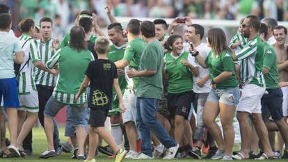 Los hinchas del Betis invadieron el c&eacute;sped para felicitar a los suyos.