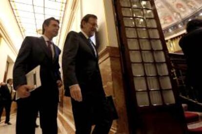 El presidente del Gobierno, Mariano Rajoy (2i), junto al ministro de Industria, Energía y Turismo, José Manuel Soria (i), a su llegada al pleno del Congreso de los Diputados.