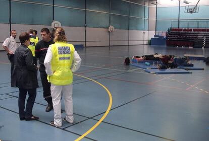 Varios estudiantes descansan en el polideportivo.