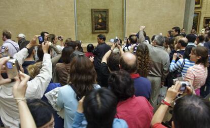 Una multitud rodea y fotografía 'La Gioconda' de Leonardo Da Vinci, en el Museo del Louvre, París.