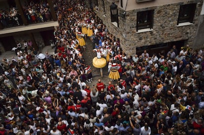 Miles de personas contemplan la bajada de los danzadores por una de las cuestas de Anguiano, La Rioja.
