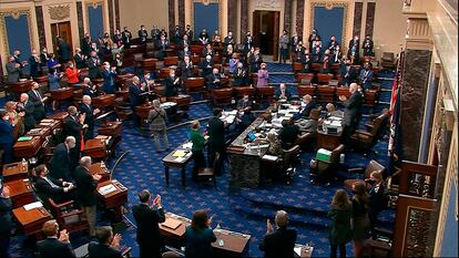 Los senadores aplauden el resultado final de la votación del plan de rescate, este sábado en Washington.