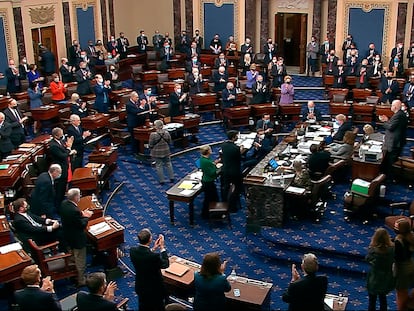Senadores aplaudem o resultado da votação do plano de resgate, neste sábado, em Washington.