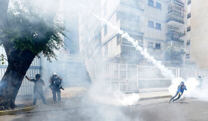 Un manifestante lanza a la policía un bote de gas lacrimógeno durante la protesta contra el gobierno venezolano de Nicolás Maduro, en Caracas.
