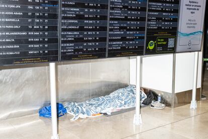 Una persona descansa en el suelo del aeropuerto Adolfo Surez Madrid Barajas. 