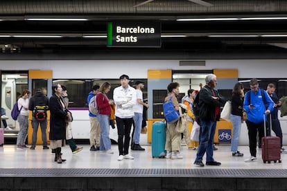 Pasajeros esperan en un andén de la estación de Sants ante los retrasos de la R3 por averías.