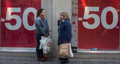 Dos mujeres, frente a un escaparate de un comercio de Granada.