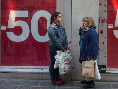 Dos mujeres, frente a un escaparate de un comercio de Granada.