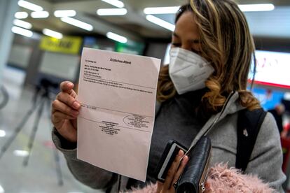 A passenger arriving in Palma de Mallorca on a flight from Germany shows her negative PCR test. 