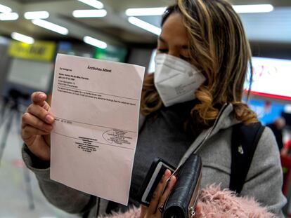 Una pasajera procedente de un vuelo de Colonia (Alemania) muestra el resultado negativo de su PCR tras aterrizar en el Aeropuerto de Palma de Mallorca.