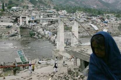 Una mujer, ante el puente que conecta las dos orillas de la ciudad paquistaní de Balakot, arrasada durante el terremoto del sábado.