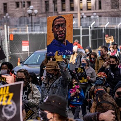 Demonstrators hold signs honouring George Floyd and other victims of racism as they gather during a protest outside Hennepin County Government Center on March 28, 2021 in Minneapolis, Minnesota. - Opening arguments begin on Monday in the trial of Derek Chauvin, the white police officer accused of killing George Floyd, a Black man whose death was captured on video and touched off protests against racial injustice across the United States and around the world. (Photo by Kerem Yucel / AFP)