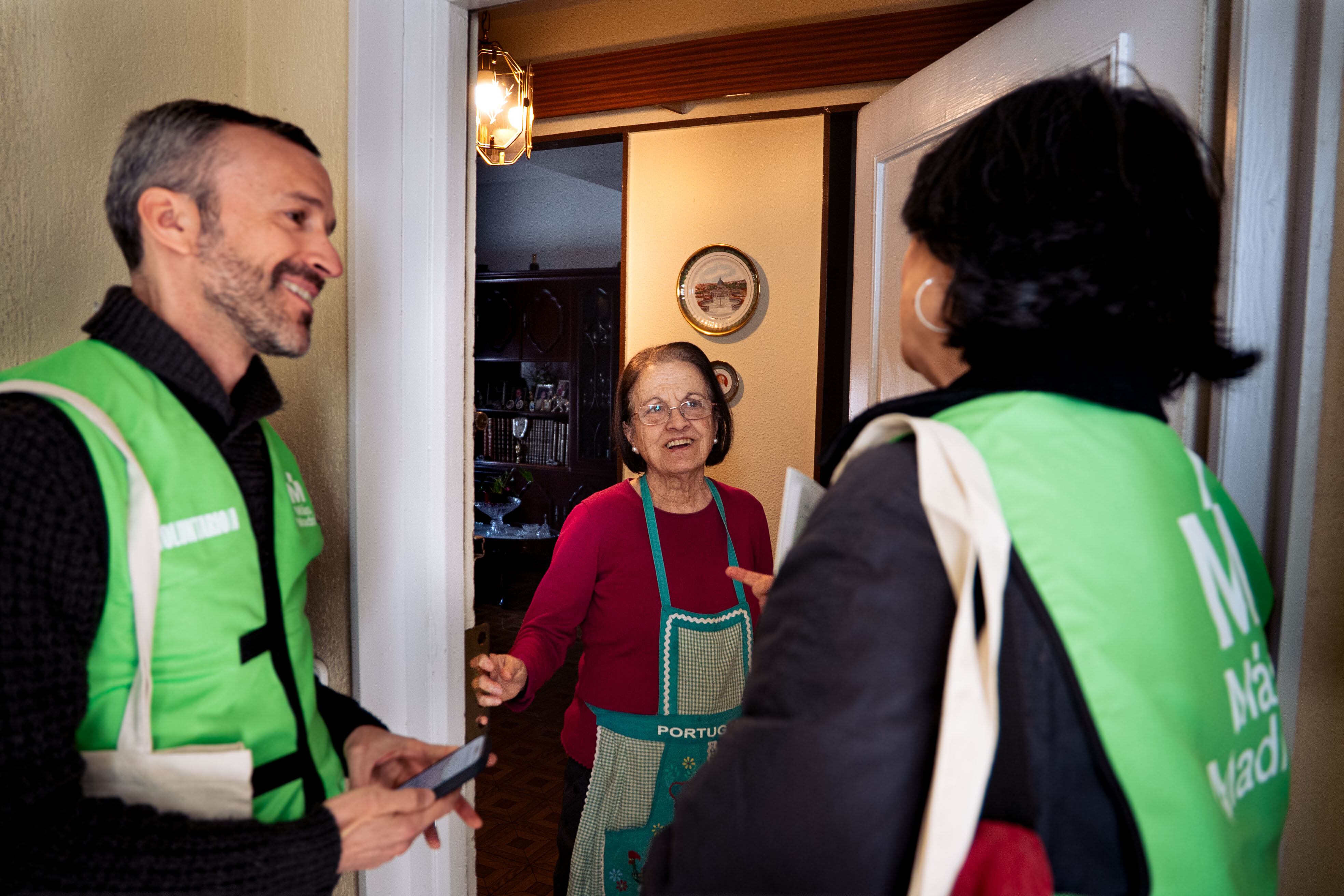 La concejala Cuca Sánchez y su compañero Julio conversan con una vecina de Arganzuela, Madrid, durante el puerta a puerta este sábado.