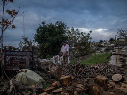 Sayed Sanki, 54, chops wood to heat his home in Mayfouk, northern Lebanon, last November.