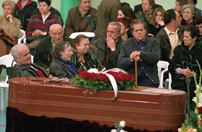 Familiares y vecinos acompañan el féretro de una de las víctimas durante el funeral celebrado en el polideportivo El Juncal de Alcalá de Henares (Madrid).