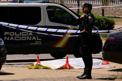 Un policía vigila la zona acordonada donde yacía aún el cuerpo del abogado ucranio Andrii Portnov, tras ser acribillado a tiros el miércoles en la puerta del colegio de sus hijas. 
