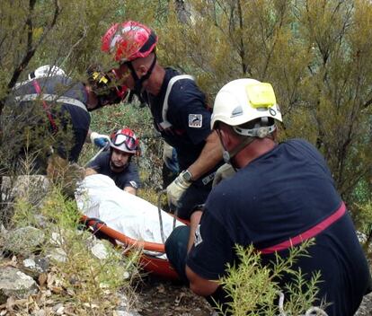 Firefighters salvage the body of V&iacute;ctor Cabedo from the mountainside last week.